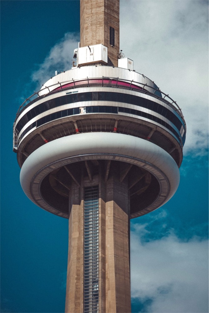 A close-up photograph of the CN Tower on a bright sunny day in Toronto, Ontario, Canada.