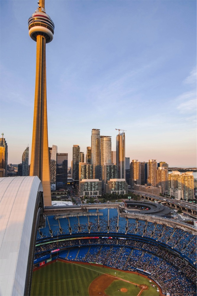 This is a photograph of a baseball game at the Rogers Centre in Toronto, Ontario, Canada. There is a lovely view of the CN Tower behind the Rogers Centre.