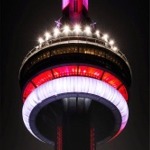 A close-up photograph of the CN Tower illuminated at nighttime in Toronto, Ontario, Canada.