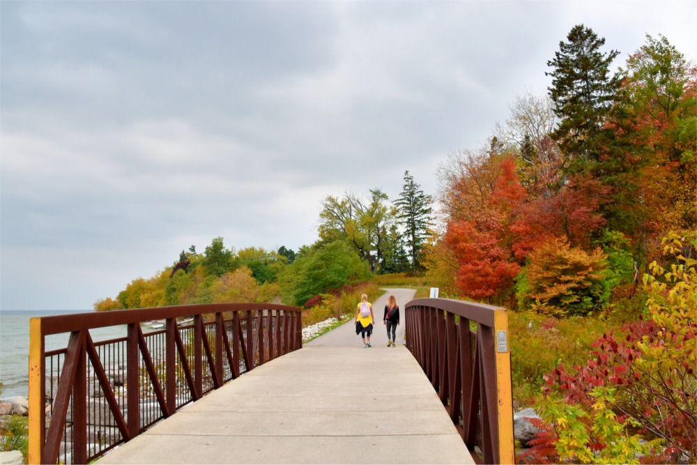 Photograph of two women walking across a bridge in the Rouge National Urban Park, Toronto, Ontario, Canada.