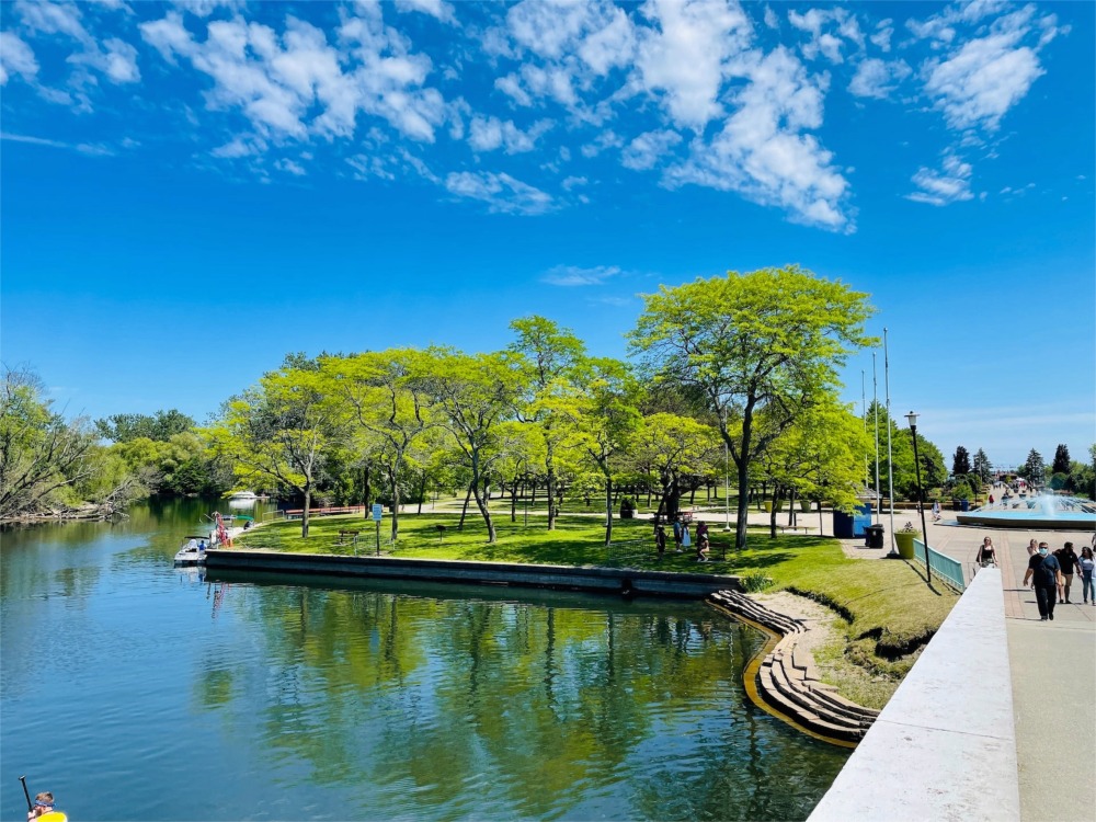 It's a beautiful fine summer's day on Centre Island Toronto and we can see people strolling along Avenue of the Island.