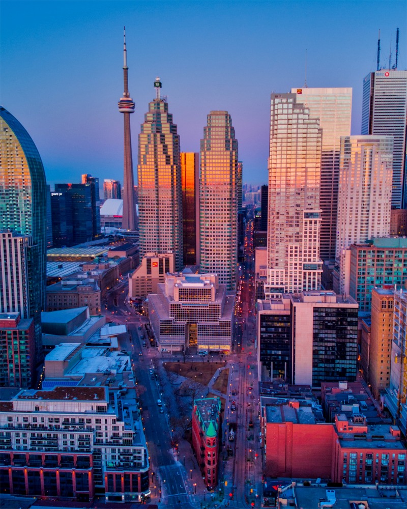 A stunning photograph of a downtown Toronto, Ontario, Canada cityscape featuring the CN Tower and the Gooderham Building aka Flatiron Building.