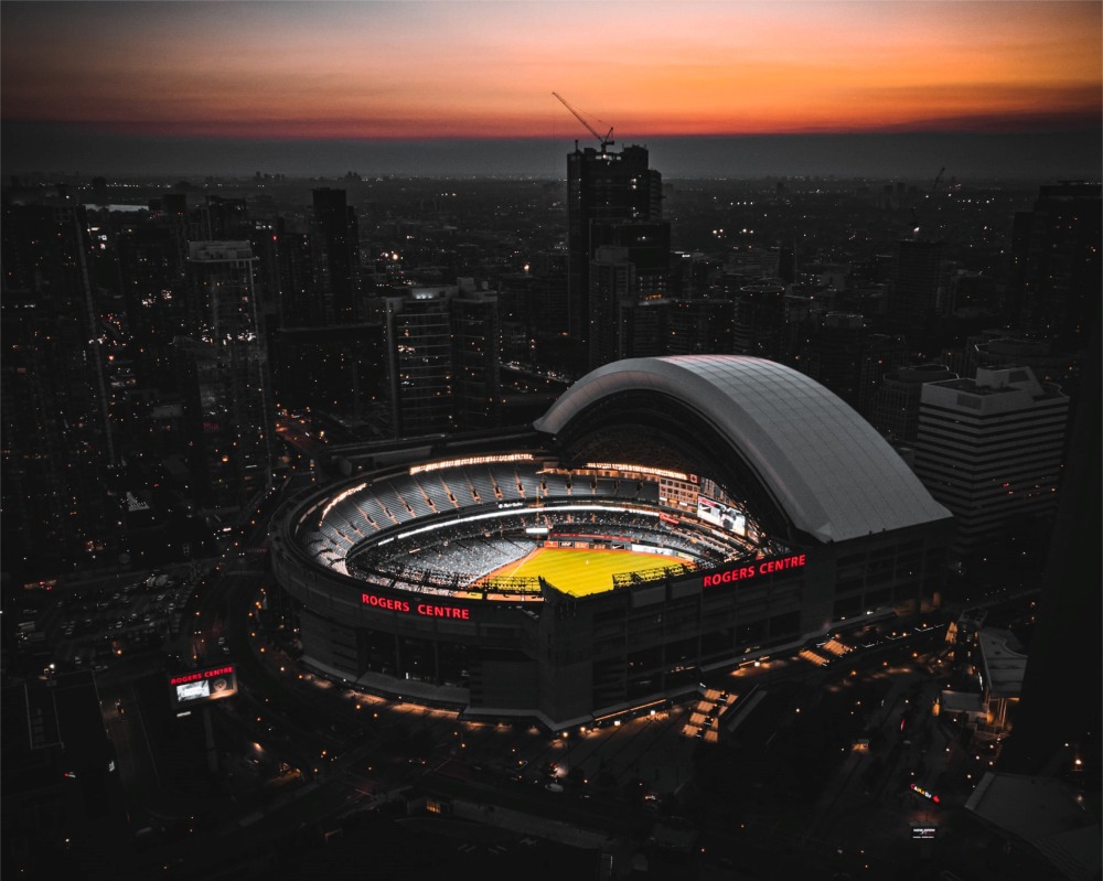 A dramatic photograph of a baseball game at the Rogers Centre in Toronto, Ontario, Canada, taken at dusk.