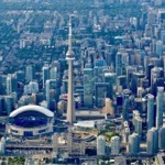 The downtown Toronto Ontario cityscape featuring the CN Tower, the Rogers Centre, the Round House Park & Toronto Railway Museum, and the Ripley's Aquarium of Canada.